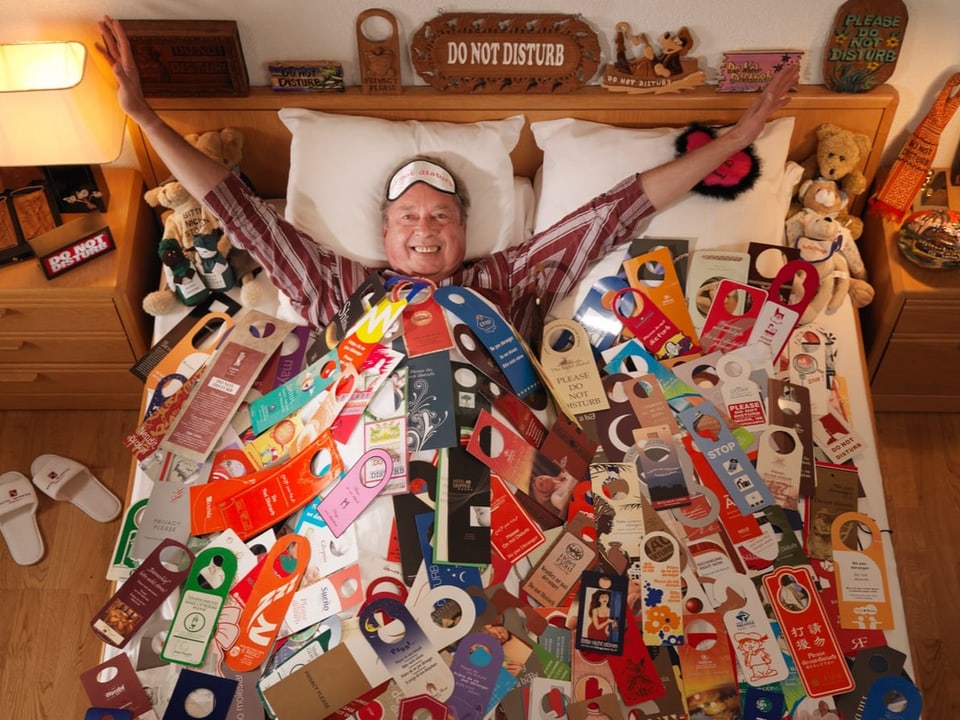 ein Mann liegt in einem Bett voller Schilder
