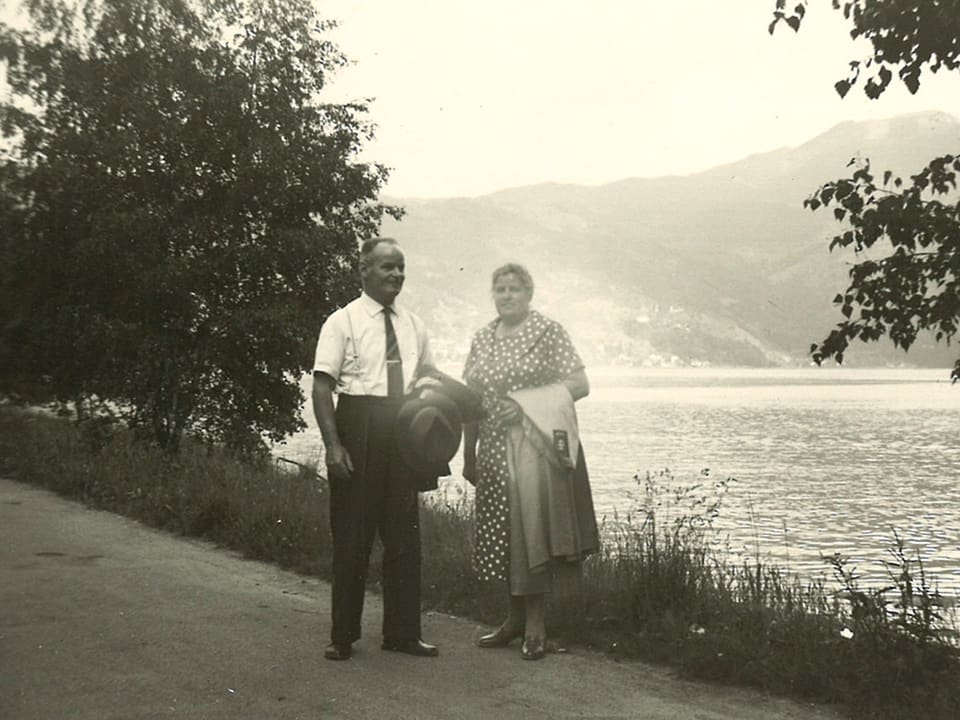 Ein älteres Ehepaar steht am Ufer eines Sees.