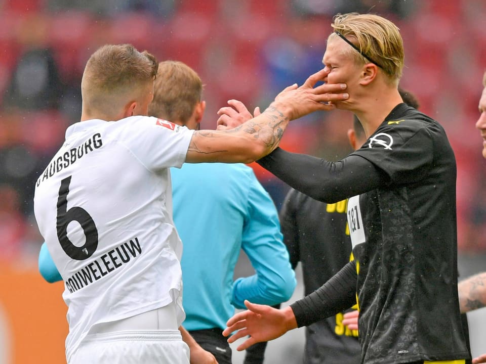 Augsburgs Jeffrey Gouweleeuw «vergreift» sich an Erling Haaland. Für den BVB setzte es in Bayern eine überraschende 0:2-Pleite ab.