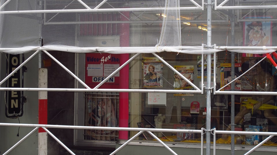 Das Schaufenster eines anderen Sexshops, mit einem Baugerüst davor. 