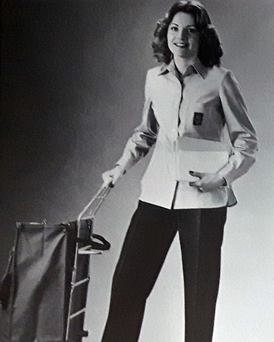 Eine Frau mit Briefkorb und Briefen in einer Uniform.