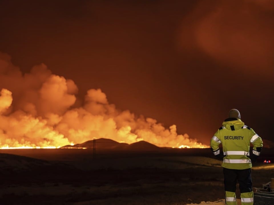 Ein Mitarbeiter der isländischen Sicherheitskräfte beobachtet den Vulkanausbruch. 