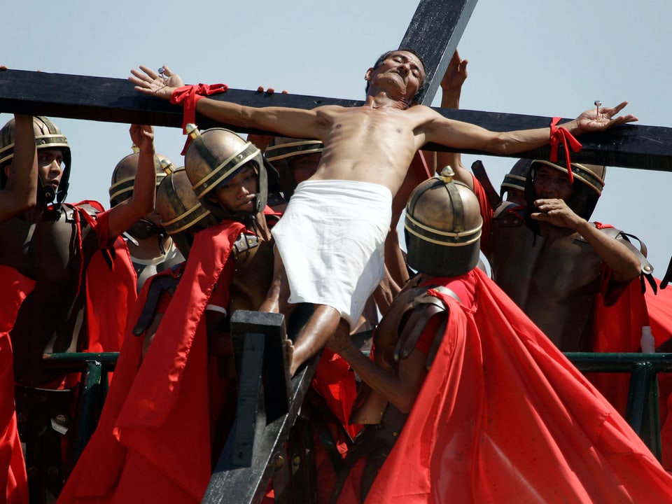 Person am Kreuz mit durchgenagelten Händen.
