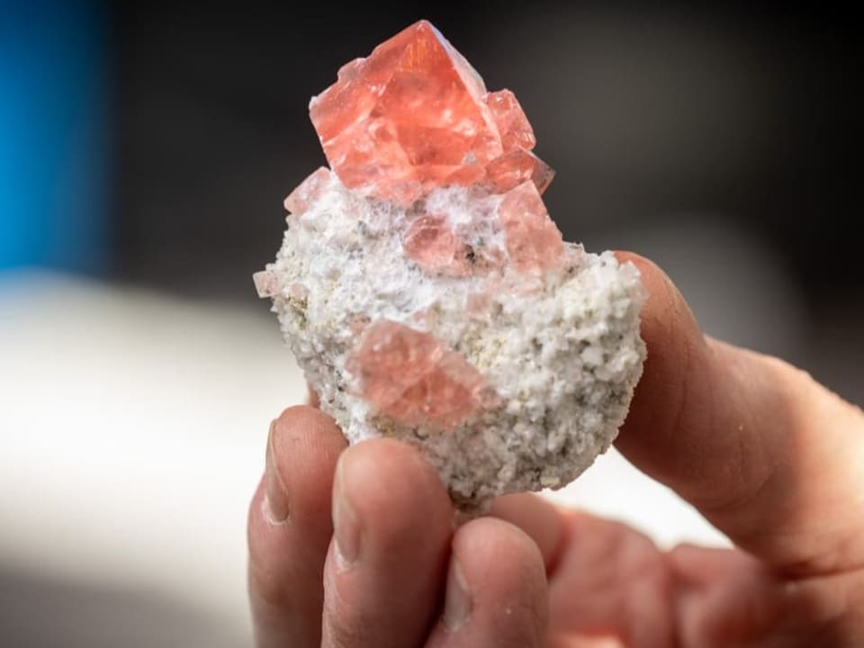 Kleiner Kristall mit feiner rosaroter Färbung an der Spitze. 
