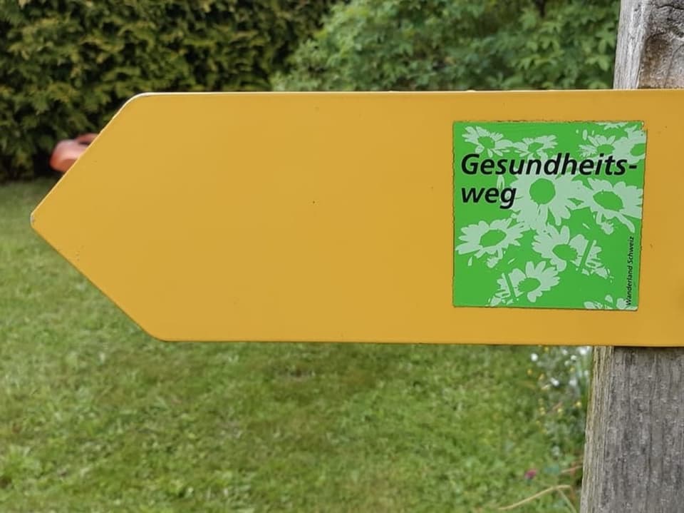Gelbes Wanderwegschild mit Aufschrift: Gesundheitsweg