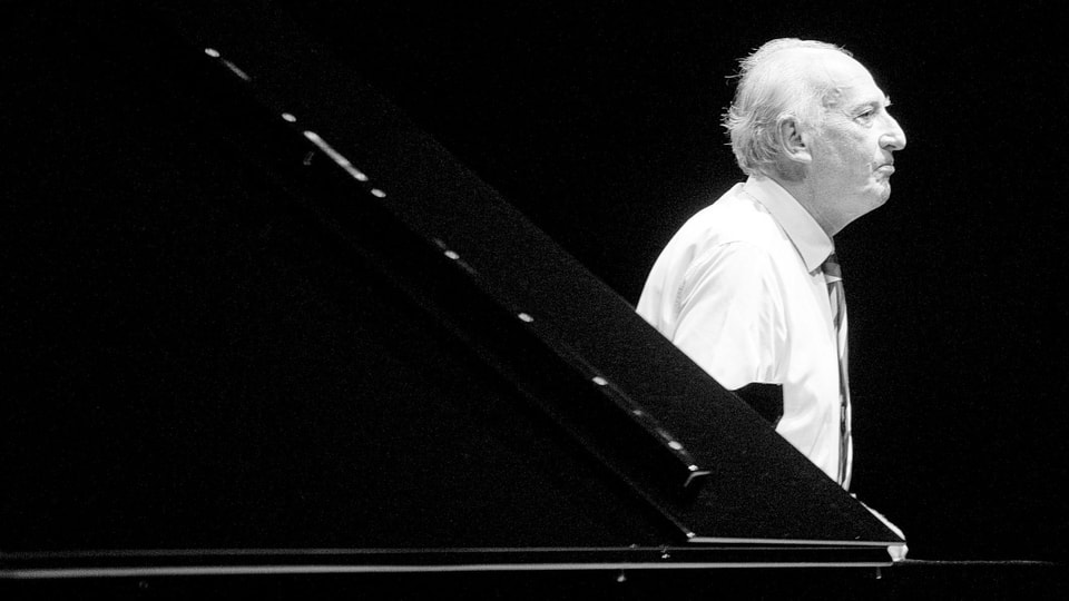Maurizio Pollini steht neben dem Klavier, seitlich fotografiert (s/w).