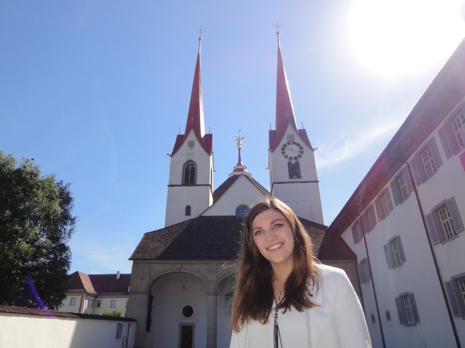 Eine Frau steht vor einer Kirche