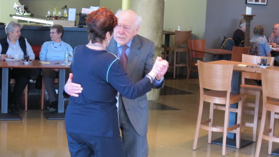 Eine ältere Dame und ein älterer Herr tanzen zusammen.