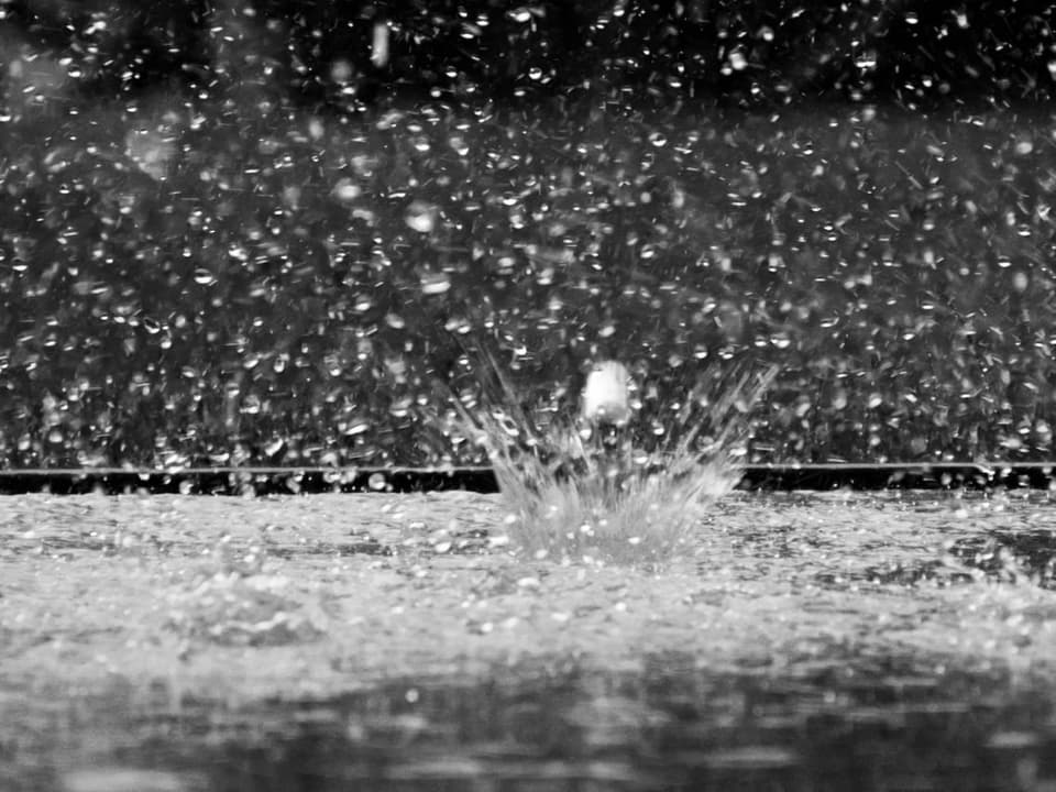 Viele Wassertropfen treffen auf Boden.