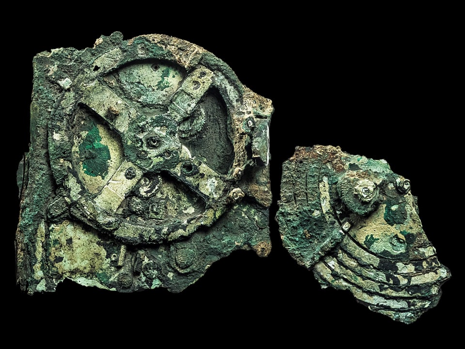 Grünliche Fragmente aus Bronze, die Zahnräder darstellen. 