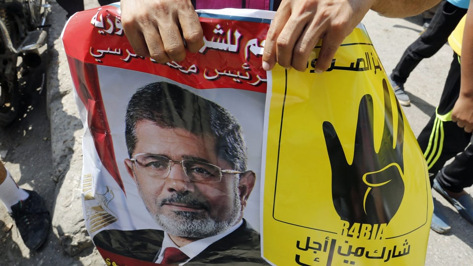 Ein Anhänger von Mohammed Mursi trägt ein Plakat des Ex-Präsidenten. (reuters)