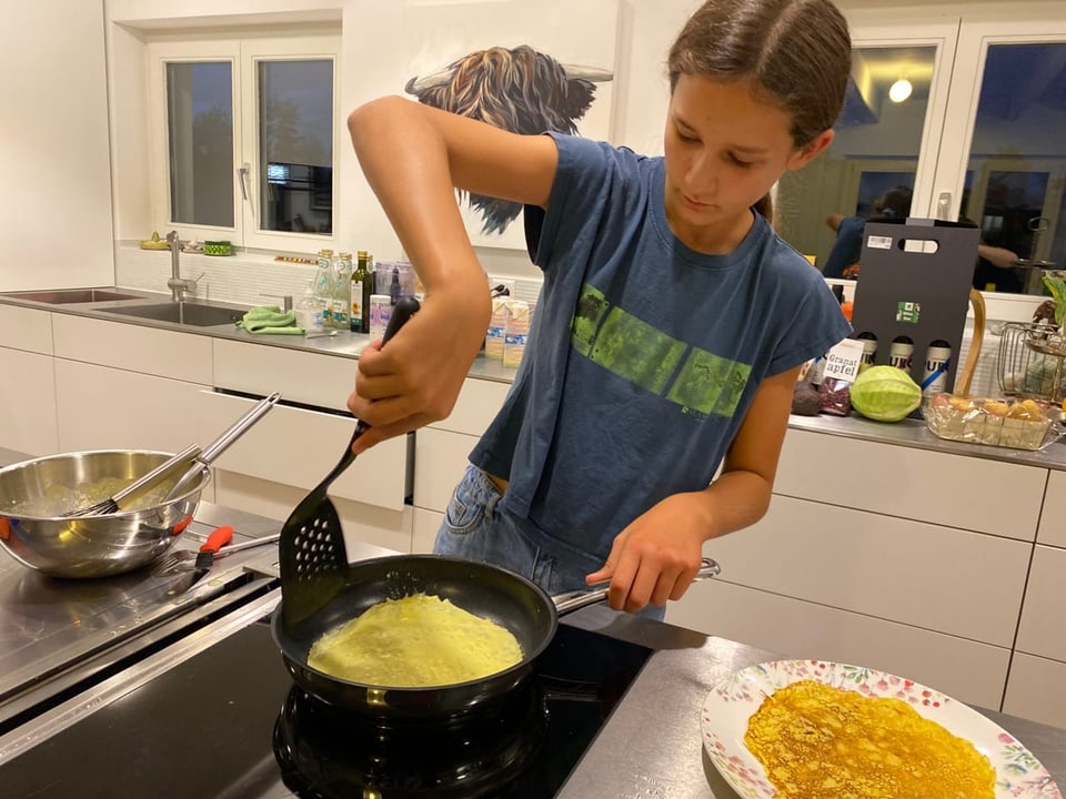 Audrey wendet die Crèpe, weil die untere Seite goldbraun gebraten ist.