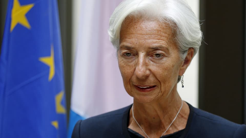 Porträt Lagarde neben EU-Fahne.