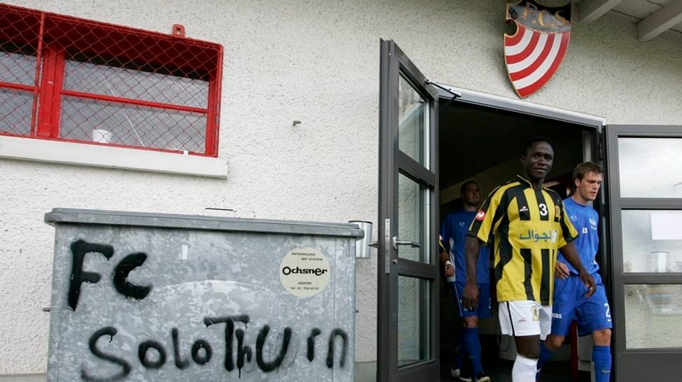 Spieler verlassen das Kabinengebäude des FC Solothurn, im Vordergrund ein Abfallcontainer mit dem Schriftzug "FC Solothurn"