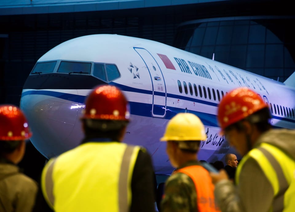 Flugzeug mit Aufschrift Air China, davor Arbeiter mit Helm.