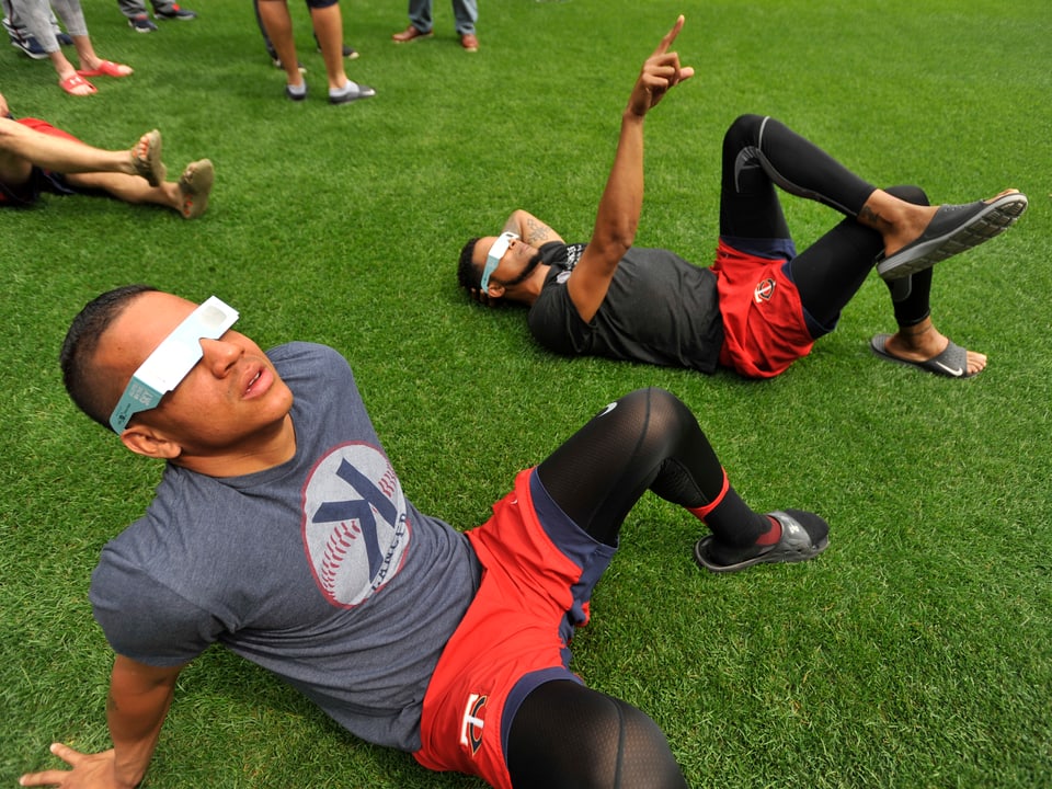 Zwei Baseballspieler schauen durch spezielle Brillen.