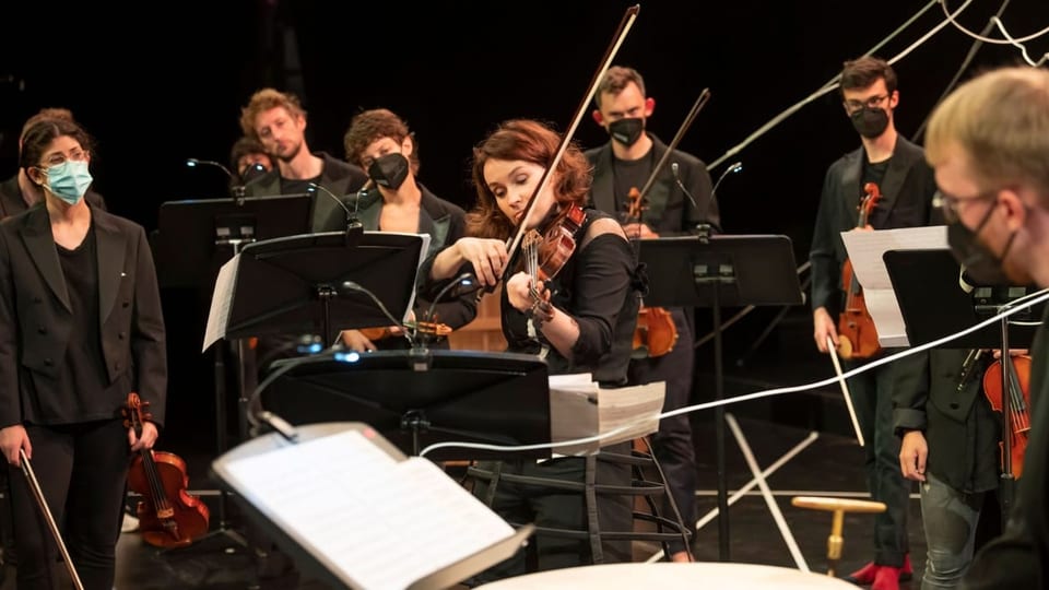 Musikerinnen und Musiker auf einer Bühne.