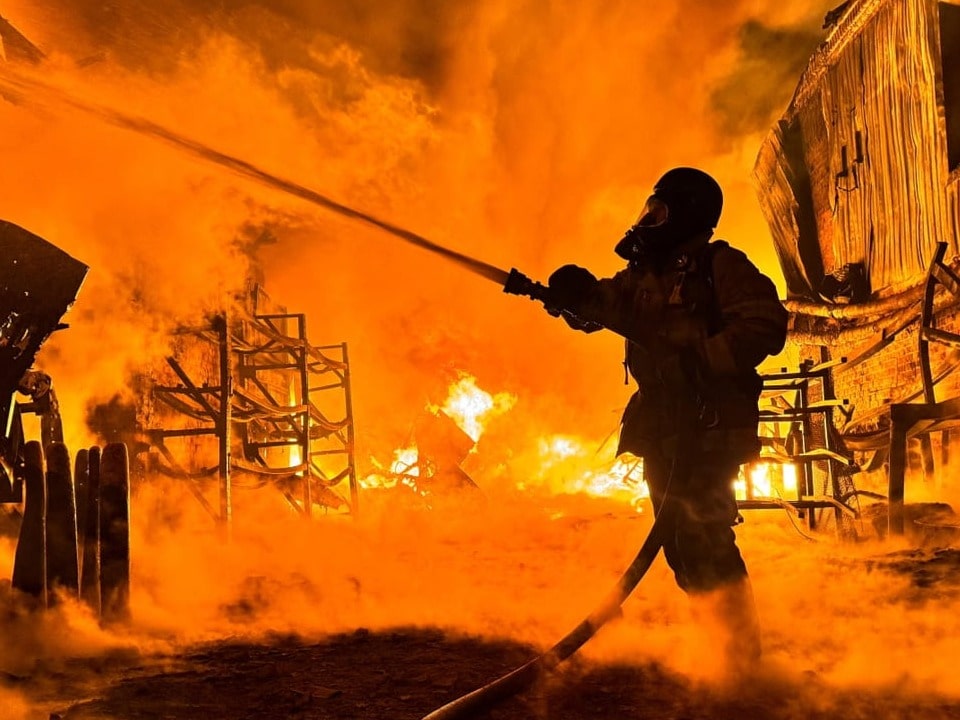 Feuerwehrmann bekämpft grosses Feuer bei Nacht