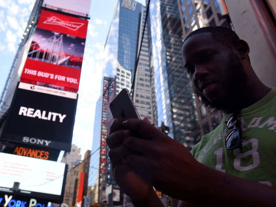 Theodore Belizaire am Times Square schaut aufs Handy.