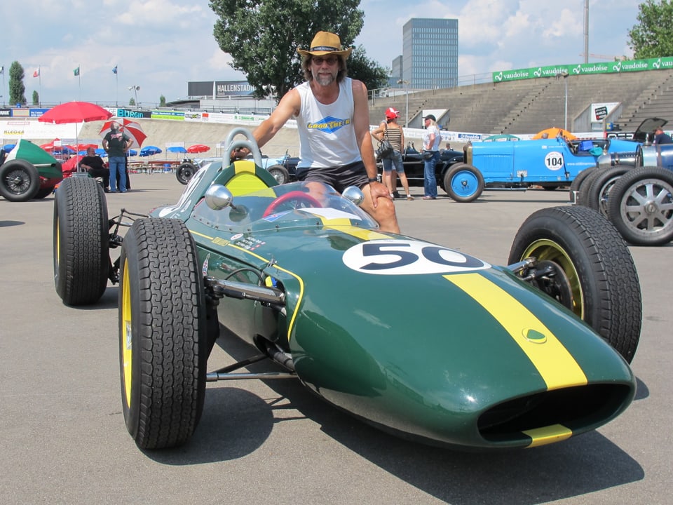 Ein grüner Lotus 24 Rennwagen, darauf ein Mann mit Cowboy Hut