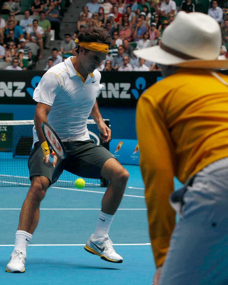 Federer spielt einen Ball zwischen den Beinen hindurch.