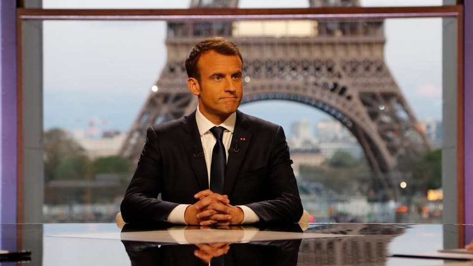 Emanuel Macron vor dem Eiffelturm bei TV-Interview.