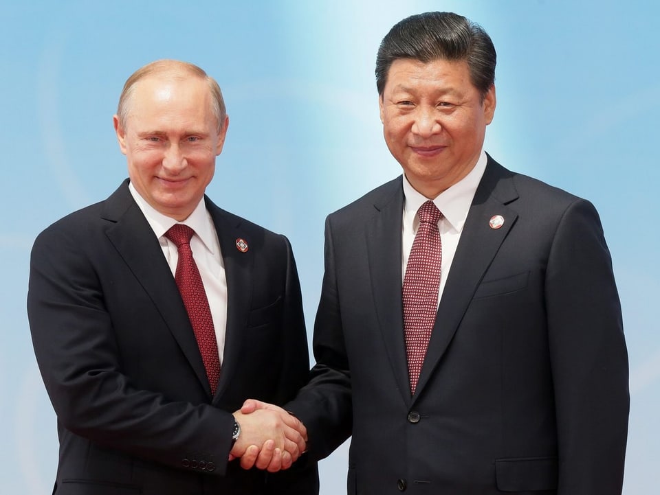 Putin und Xinping geben sich die Hand.