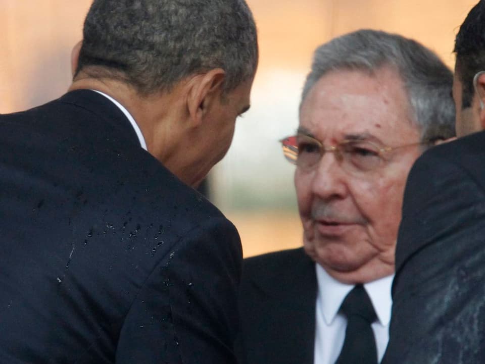 Obama mit dem Rücken zur Kamera und Raul Castro.