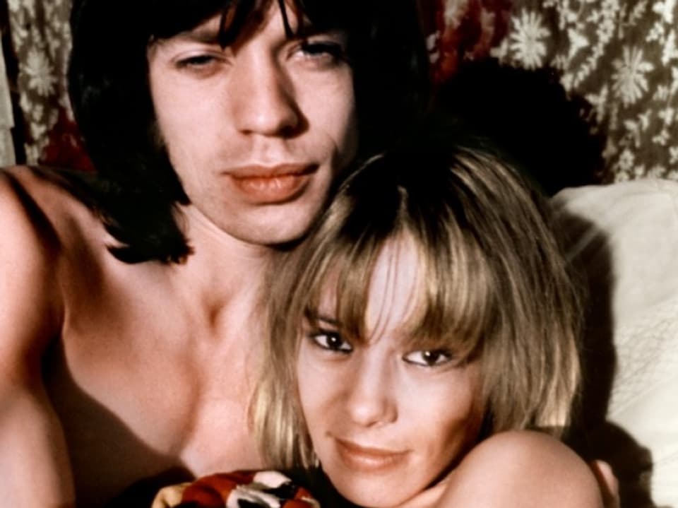 Porträt Mick Jagger mit Anita Pallenberg im Arm nackt im Bett.