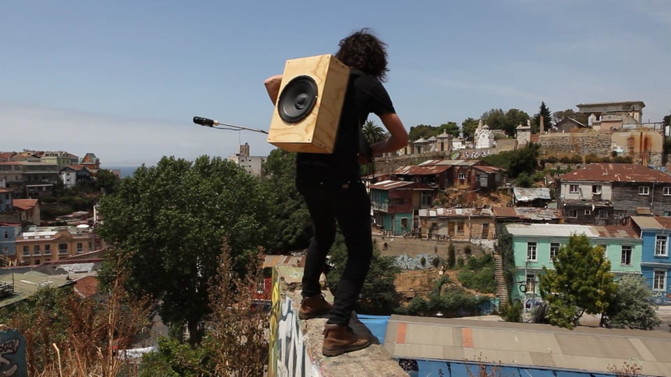 ein Mann steht mit einem Mikrofon auf einem Dach in einer Stadt