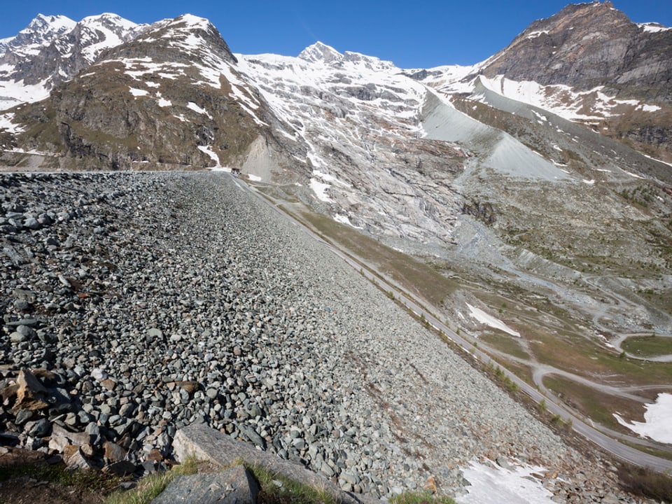 Staudamm mit Gletscher im Hintergrund.
