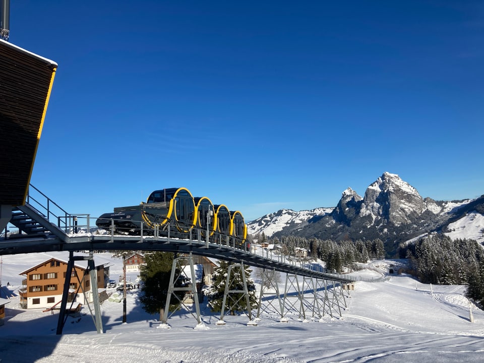 Die Stoosbahn verlässt die Bergstation bei schönstem Wetter. Im Hintergrund die Mythen.