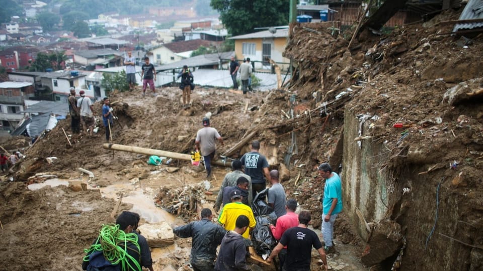 Männer transportieren eine Leiche nach heftigen Regenfällen in Petrópolis.