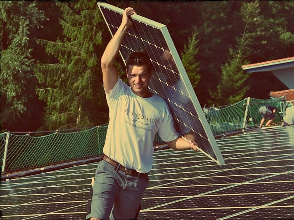 Fabian Dubach trägt eine Sonnenkollektoren-Installation.