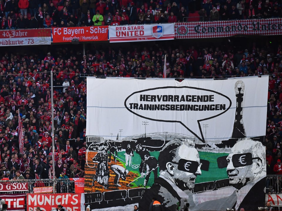 Bayern-Fans halten ein Transparant hoch.