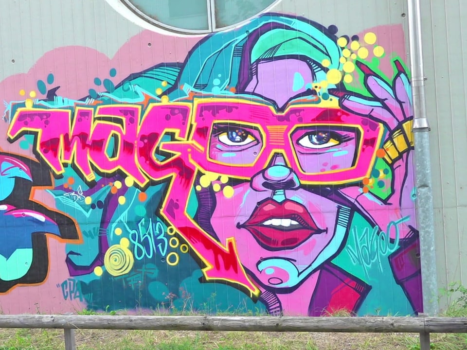 Poppiges Graffiti im Andy Warhol-Stil. Es zeigt eine Frau mit einer pinken Brille.