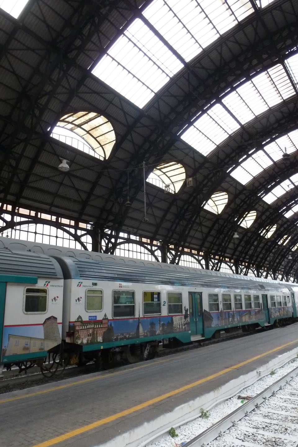 Ein Zug mit Bildern von Sehenswürdigkeiten steht im Bahnhof Mailand.