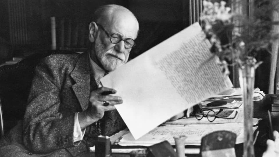 Freud liest ein beschriebenes Stück Papier