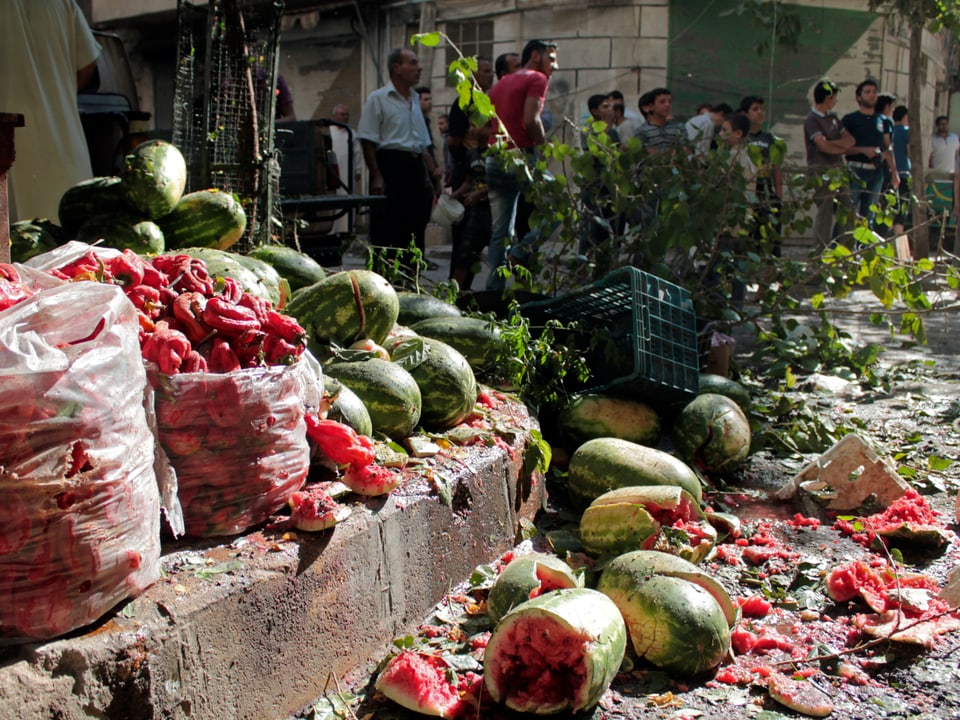 Durch Granatensplittter zerstörte Gemüse und Früchte eines Marktstandes.