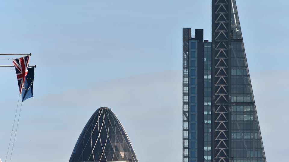 Zwei Wolkenkratzer neben einer EU- und einer Grossbritannien-Flagge.