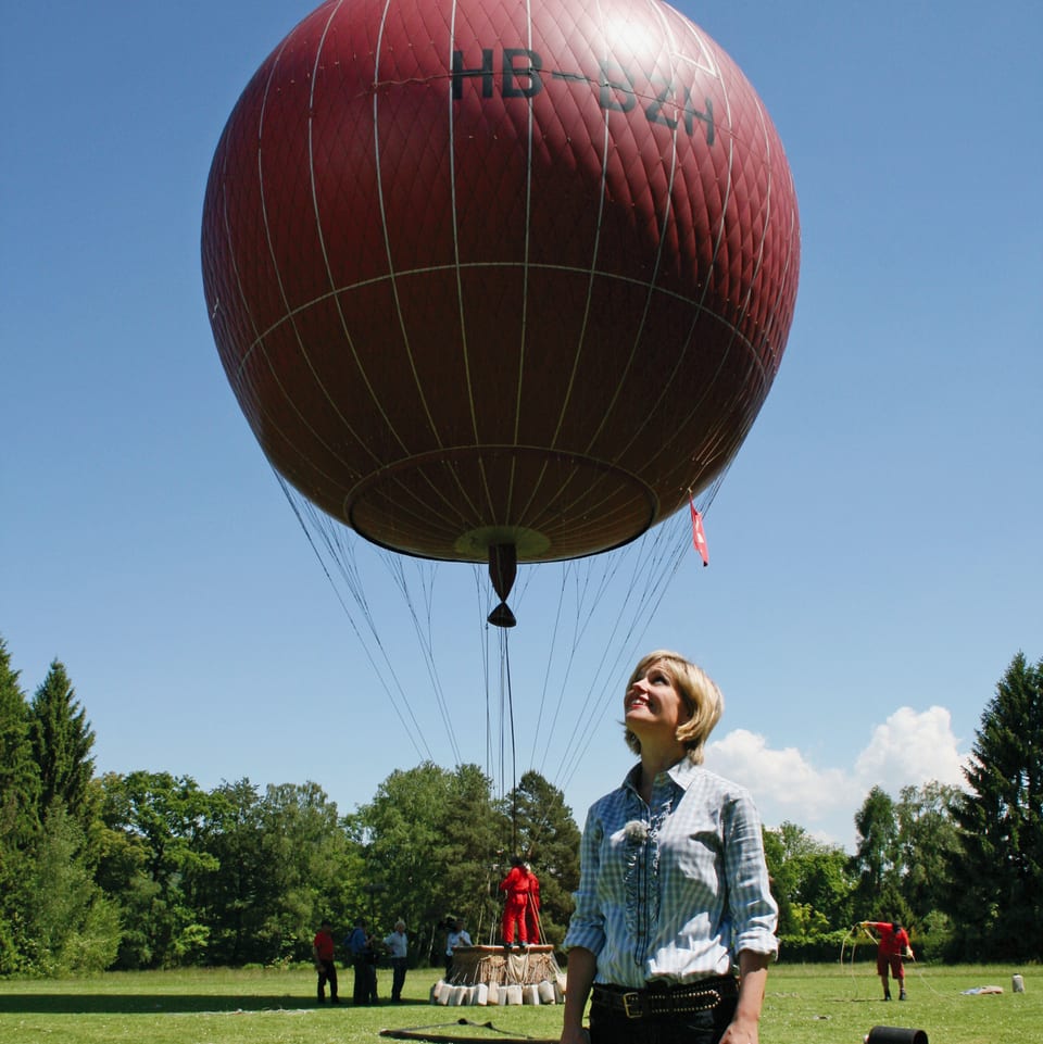 Sabine in grüner Wiese mit rotem Gasballon in Luft