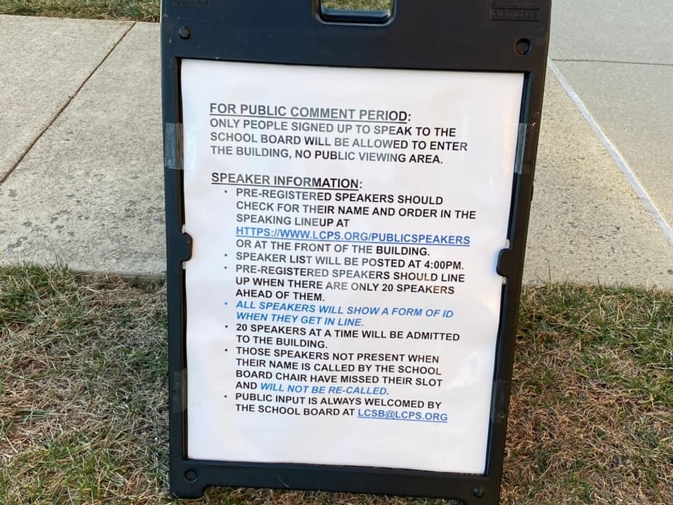 Ein Schild auf dem Gras vor dem Gebäude