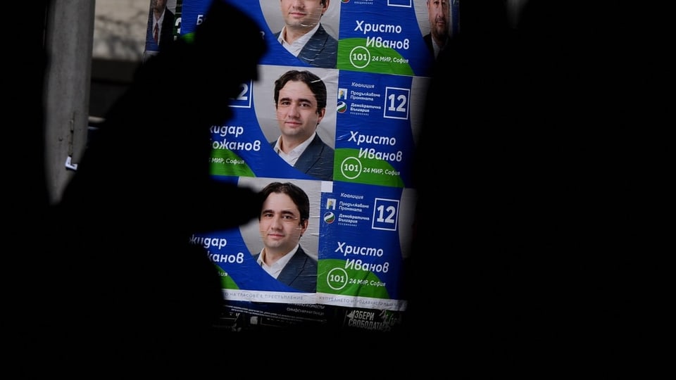 Eine Person läuft an einem bulgarischen Wahlplakat vorbei.