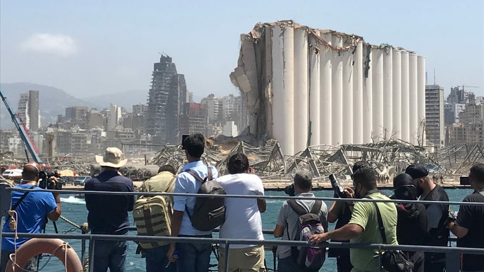 Journalisten fotografieren zerstörte Skyline