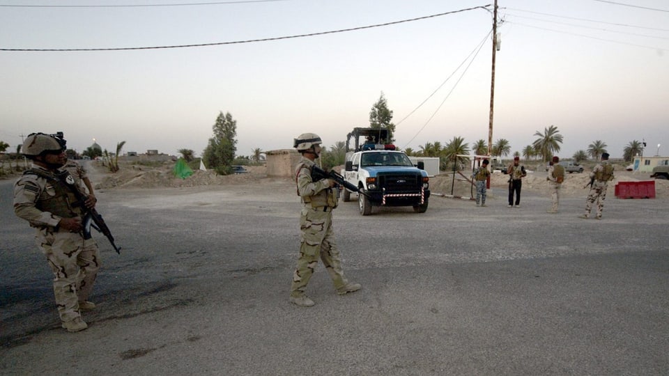 Soldaten mit Gewehren in der Wüste.
