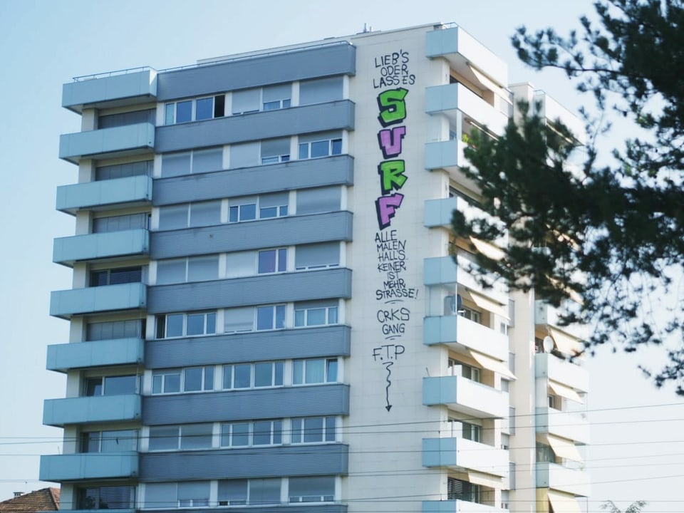 Basler Hochhaus; von oben nach unten hat jemand eine Botschaft gesprayt: Alle malen Halls, keiner ist mehr Strasse.