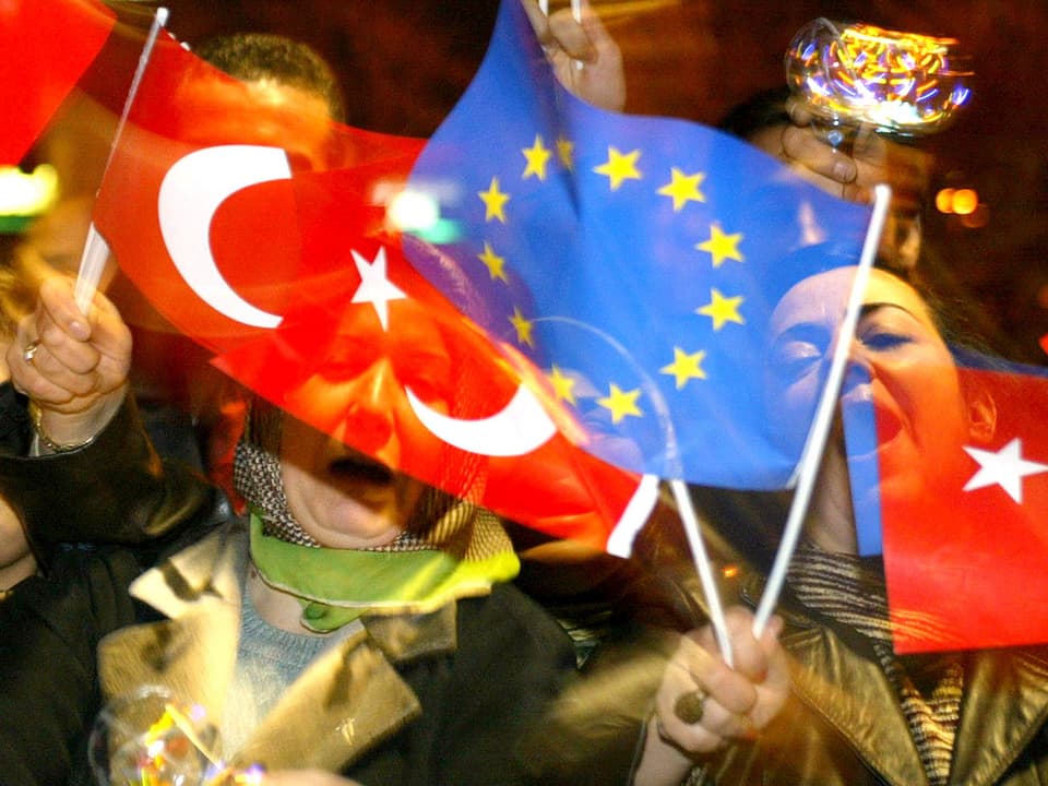 Türken winken mit EU- und Türkei-Fähnchen.