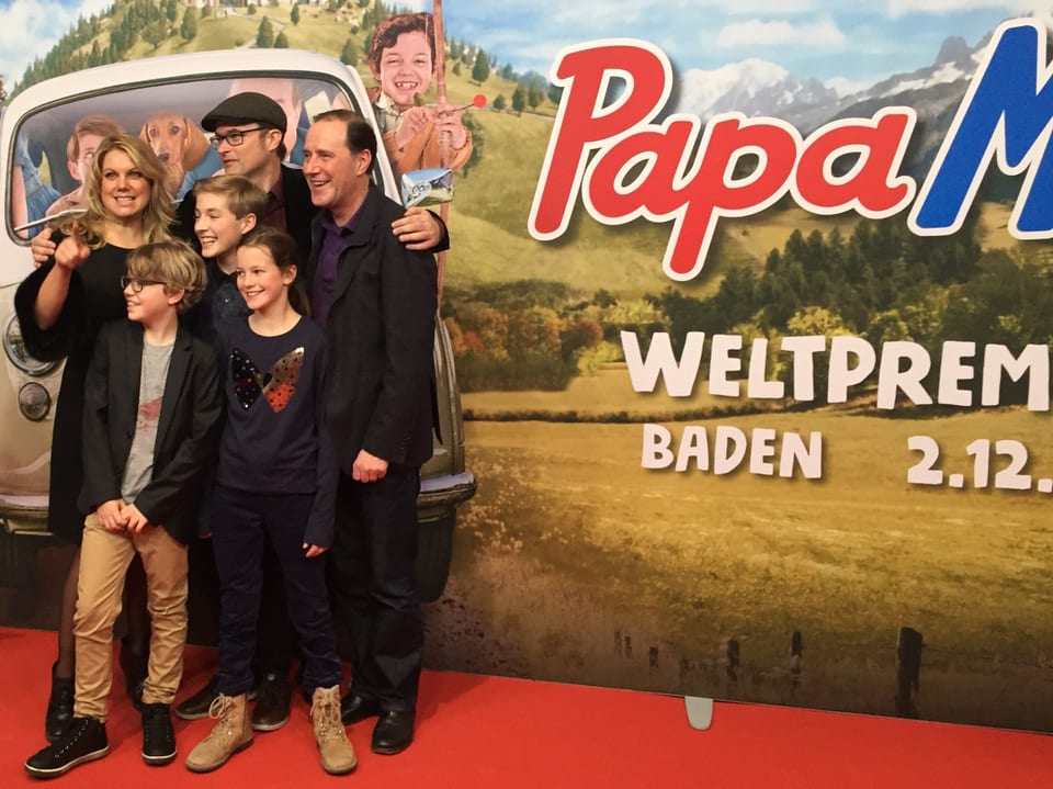 Eine Gruppe von Schauspielern vor riesigem Papa Moll-Plakat