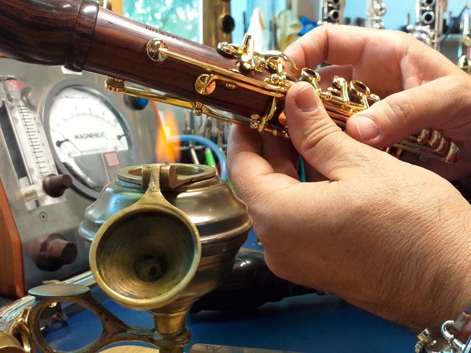 Eine Klarinette wird über eine Öllampe gehalten.