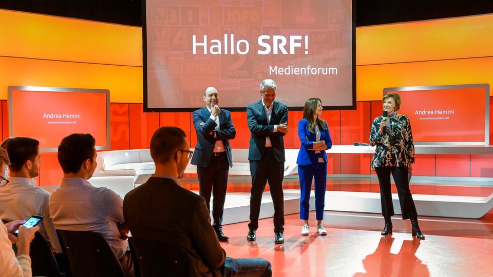 Begrüssen im Sportstudio die Teilnehmerinnen und Teilnehmer zum «Hallo SRF! Medienforum» bei SRF in Zürich Leutschenbach: Urs Leuthard (Moderator Abstimmungs- und Wahlsendungen), Sandro Brotz (Moderator «Arena»), Susanne Wille (Politmoderatorin) und Andrea Hemmi (Kommunikationschefin SRF)